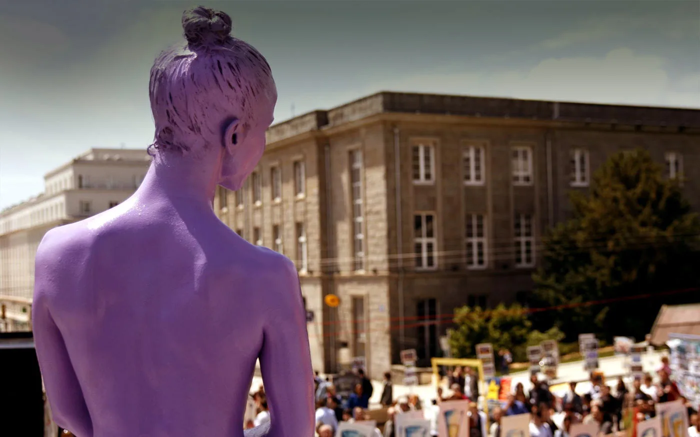 The back of violet character looking at people on a sunny day. One moment of the people of colors a street theater show by the ilotopie company