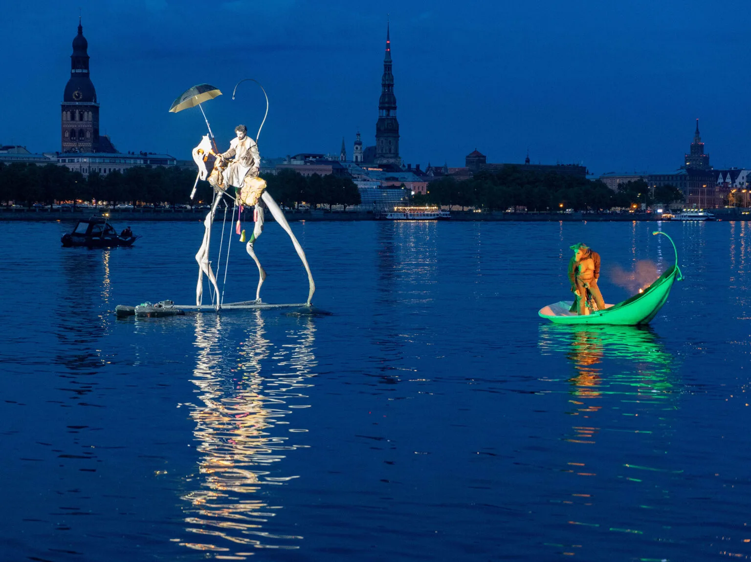 A floating horse and its rider, a petal carrying a person and fire, an image from an ilotopie show "The extraordinary Journey" here in Riga. The city on the back.