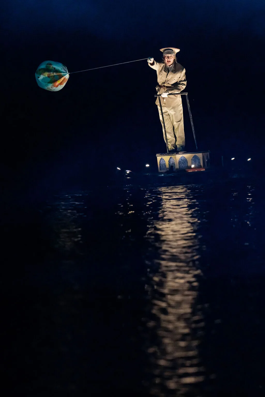 The show on the water, the extraordinary journey of the ilotopie company : A général standing on a pedestal on the water makes an inflatable earth dance around his head.