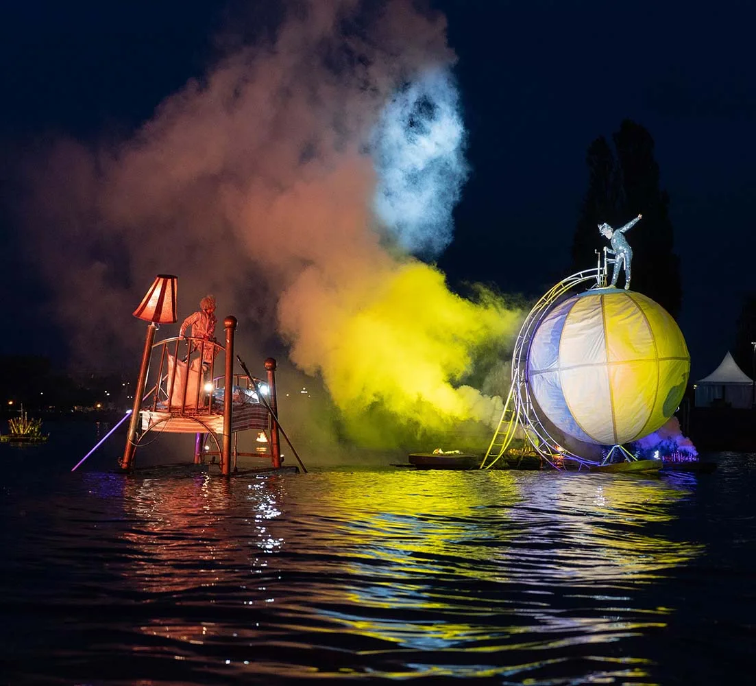 fireworks display on the water "An Extraordinary Journey" there in Fos-sur-mer, France, A young dreamer on a big floating ber looking at Gaïa, a dancer on a giant floating earth.