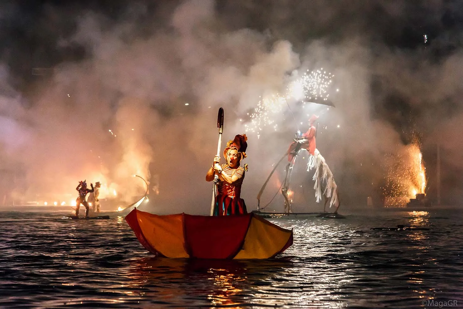Pyrotechnical watershow-the Extraordinary Journey-the umbrella clown, ilotopie. A clown on the water on a upsidedown big umbrella.