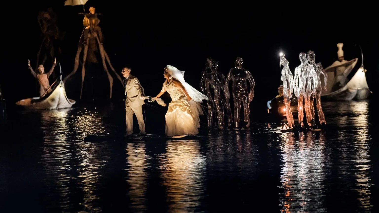 during the water show the Extraordinary Journey, the beginning of the floating wedding procession in dark water.