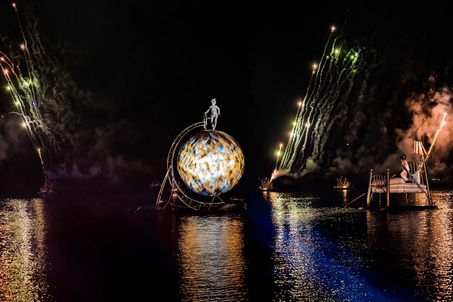 A dreamer on a bed, a kaleidoscopic earth with a walking character on it, fire works on the back, all of this on the water. It is on of the special scene of the water show The Extraodinary Journey.
